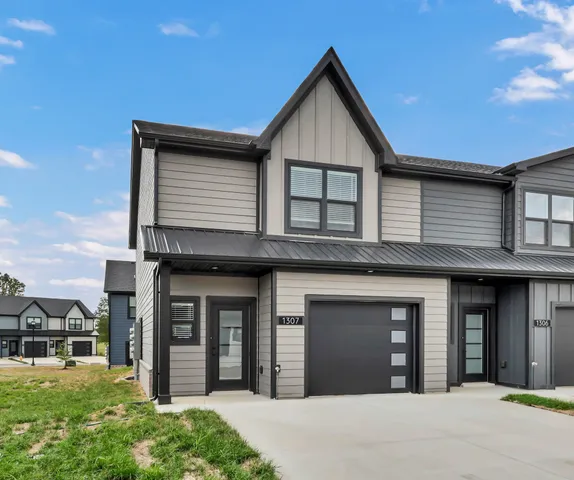 a view of a house with a yard and potted plants