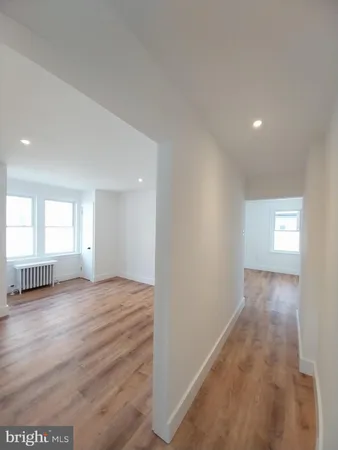 a view of an empty room and window and wooden floor