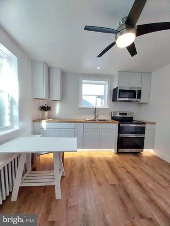 a kitchen with granite countertop a stove a sink and a microwave