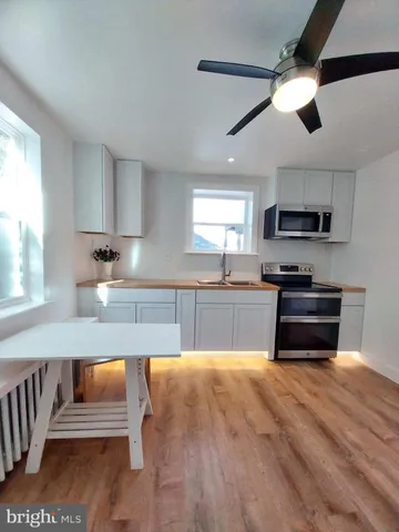 a kitchen with granite countertop a stove a sink and a microwave