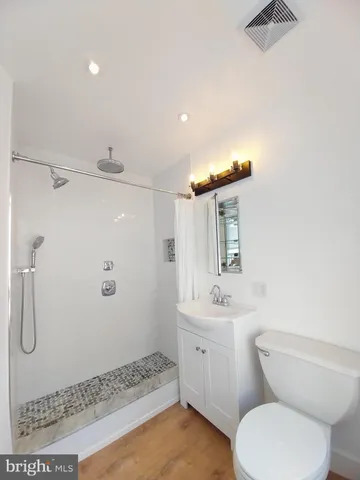 a bathroom with a sink a toilet and shower
