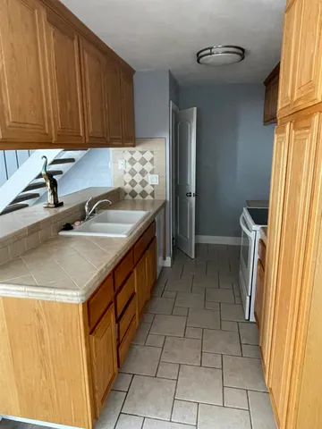 a kitchen with a sink a stove and a refrigerator