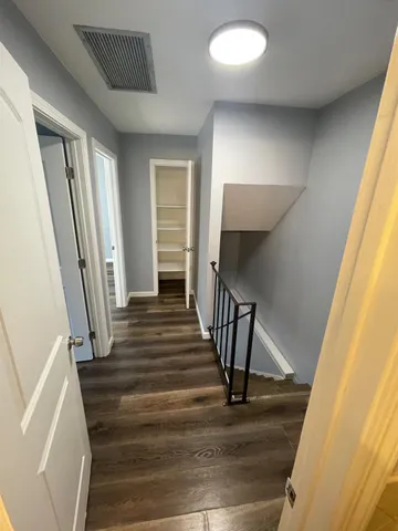 a view of a hallway with wooden floor and staircase