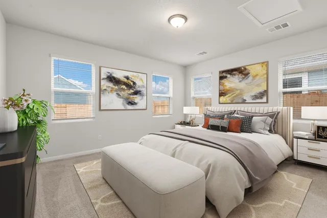 a bedroom with bed and a painting on the wall