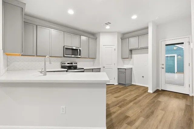 a kitchen with granite countertop a refrigerator and a stove top oven