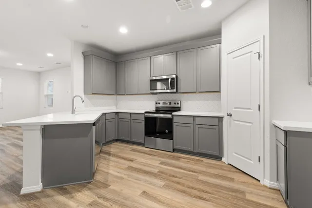 a kitchen with granite countertop white cabinets and stainless steel appliances