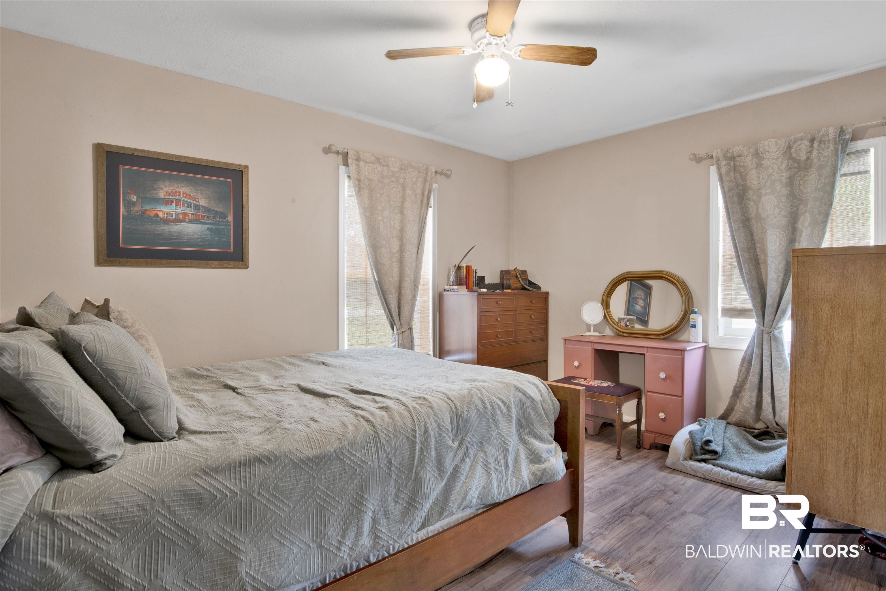 1100 North Pine Street Foley, AL 36535 - Photo 11 of 30 Bedroom featuring wood-finish flooring, two large windows with valances, a ceiling fan with integrated lighting, and neutral wall tones