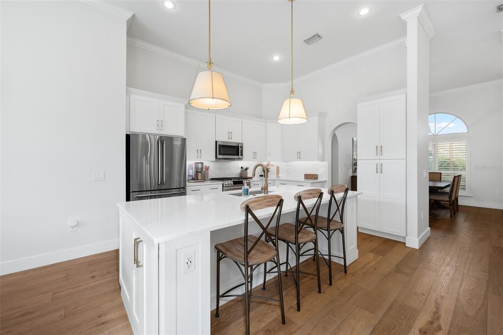 13549 Northwest 9 Road Newberry, FL 32669 - Photo 12 of 42 a kitchen with stainless steel appliances a table chairs refrigerator and microwave
