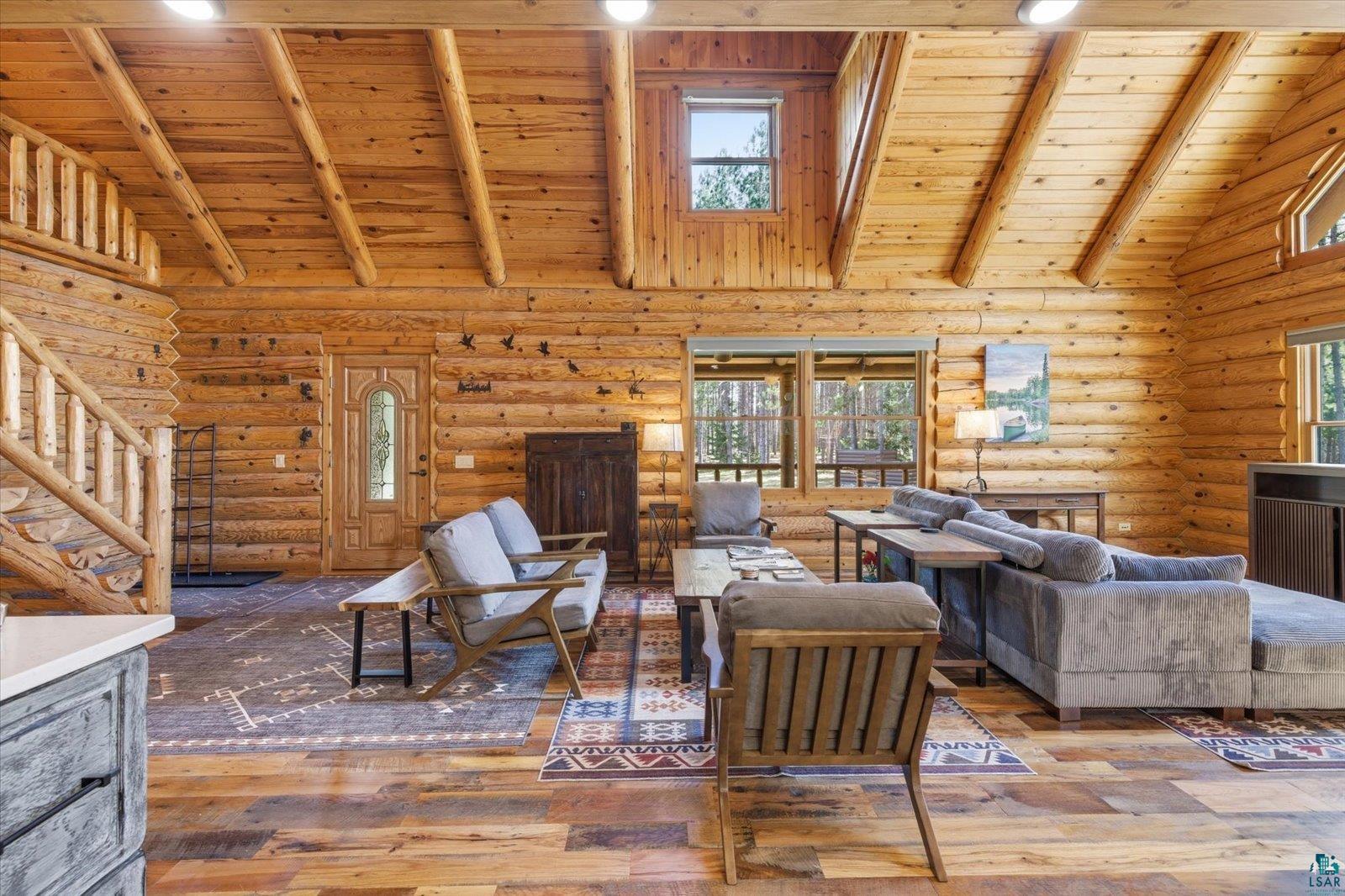 7185 Giants Ridge Road Embarrass, MN 55732 - Photo 11 of 47 Spacious log cabin interior featuring vaulted ceilings with exposed beams, wood-finish flooring, and multiple windows
