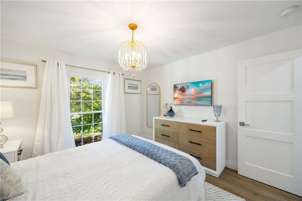 4732 West Boulevard, Unit E5 Naples, FL 34103 - Photo 12 of 40 Bedroom featuring dark hardwood / wood-style flooring and a chandelier