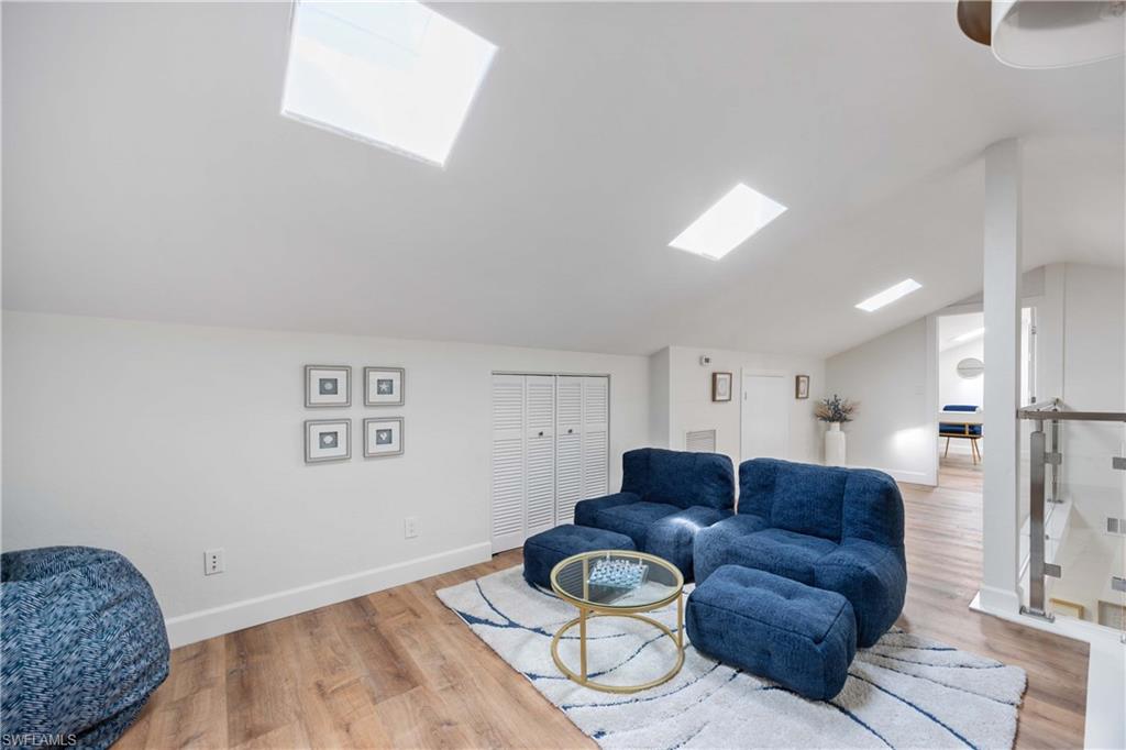 4732 West Boulevard, Unit E5 Naples, FL 34103 - Photo 17 of 40 Sitting room featuring vaulted ceiling with skylight and light wood-type flooring