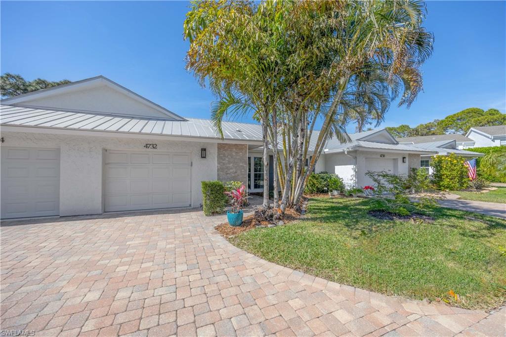 4732 West Boulevard, Unit E5 Naples, FL 34103 - Photo 32 of 40 Ranch-style home featuring a garage and a front lawn