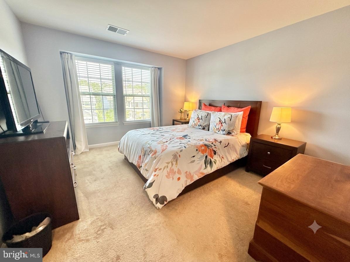 17875 Sugarberry Road Dumfries, VA 22026 - Photo 18 of 30 a bedroom with a bed and a flat tv screen on dresser