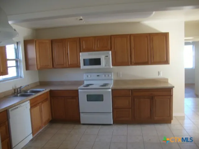a kitchen with a stove sink and cabinets
