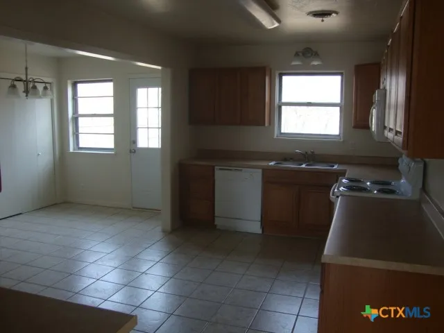 a kitchen with a sink a window and cabinets
