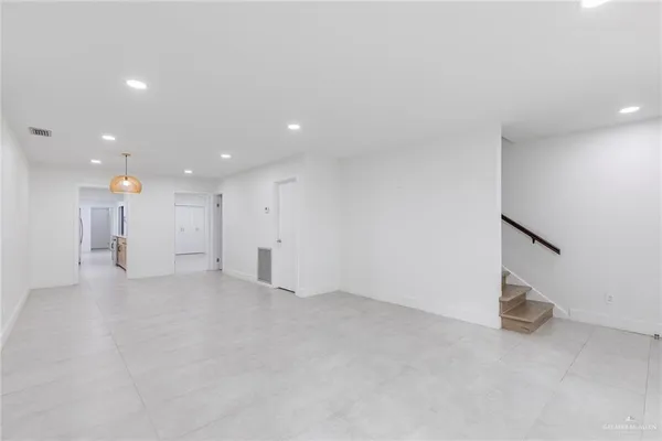an empty room with windows and cabinet