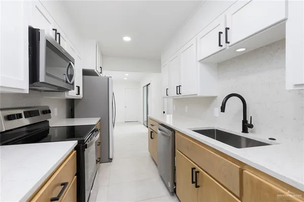 a kitchen with stainless steel appliances granite countertop a stove a sink and a microwave