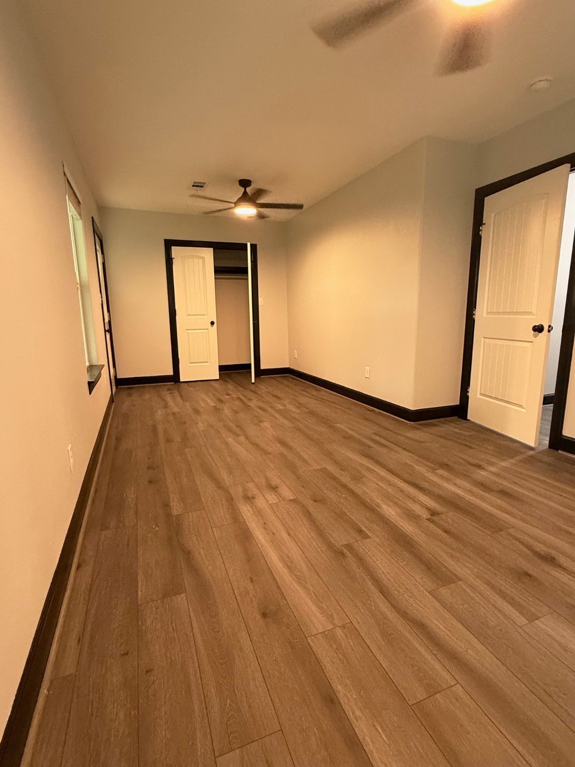 14213 4th Street Santa Fe, TX 77517 - Photo 12 of 20 a view of an empty room with wooden floor and a window