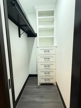 a view of walk in closet with empty racks