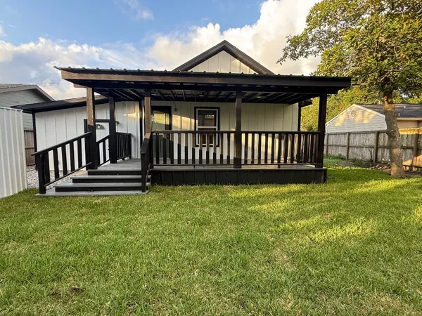 a view of a house with a small yard and wooden fence