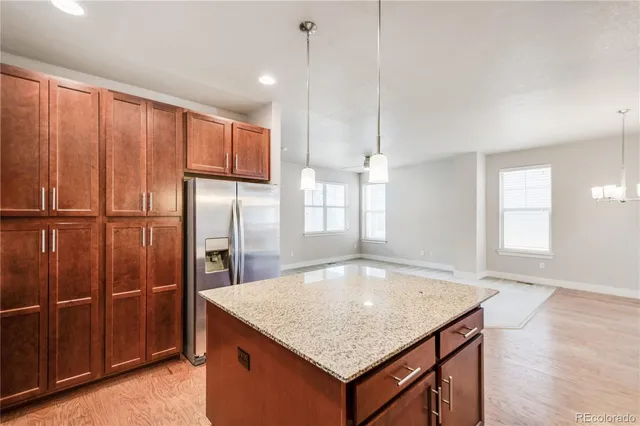 a kitchen with stainless steel appliances granite countertop a refrigerator a sink and a cabinets