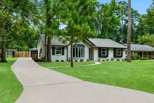 a front view of a house with a garden and trees