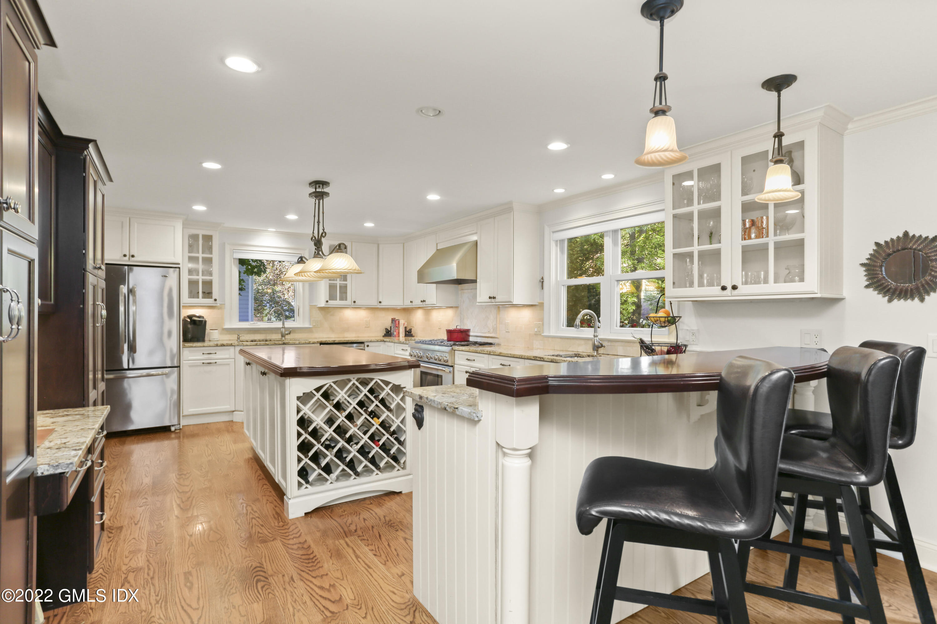 23 Split Timber Place Riverside, CT 06878 - Photo 8 of 32 a kitchen with a dining table chairs wooden cabinets and refrigerator