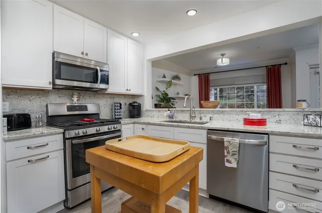 a kitchen with stainless steel appliances granite countertop a stove and a sink