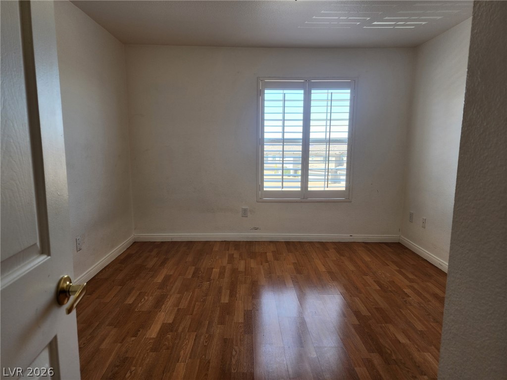 231 West Horizon Ridge Parkway, Unit 1127 Henderson, NV 89012 - Photo 31 of 39 A well-lit bedroom features durable laminate flooring and a window dressed with plantation shutters.