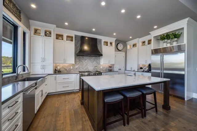 a large kitchen with a table chairs wooden floor and appliances