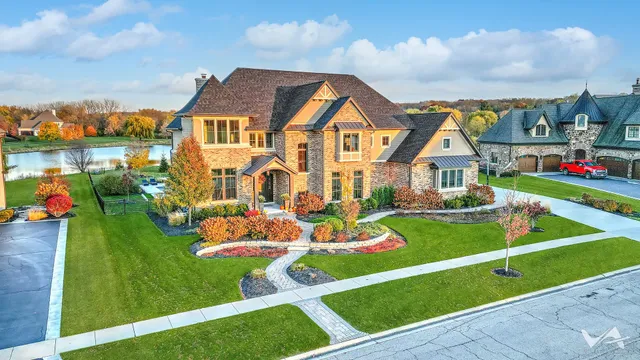 a front view of a house with yard and lake view