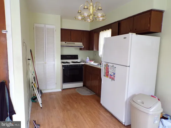 a kitchen with stainless steel appliances a refrigerator sink and wooden floor