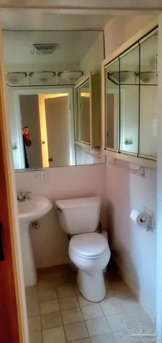 a bathroom with a toilet sink and mirror