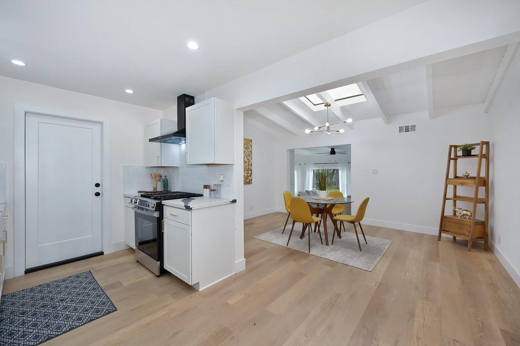 2316 West Swain Road Stockton, CA 95207 - Photo 17 of 46 a kitchen with stainless steel appliances granite countertop a stove top oven a sink dishwasher and white cabinets with wooden floor