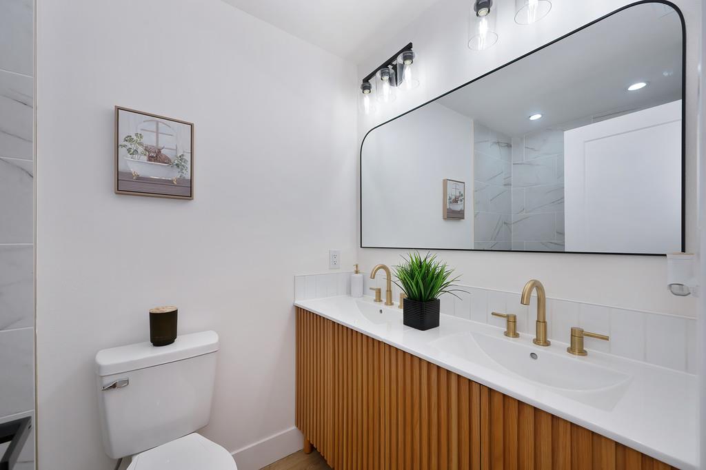 2316 West Swain Road Stockton, CA 95207 - Photo 37 of 46 a bathroom with a sink a toilet and mirror