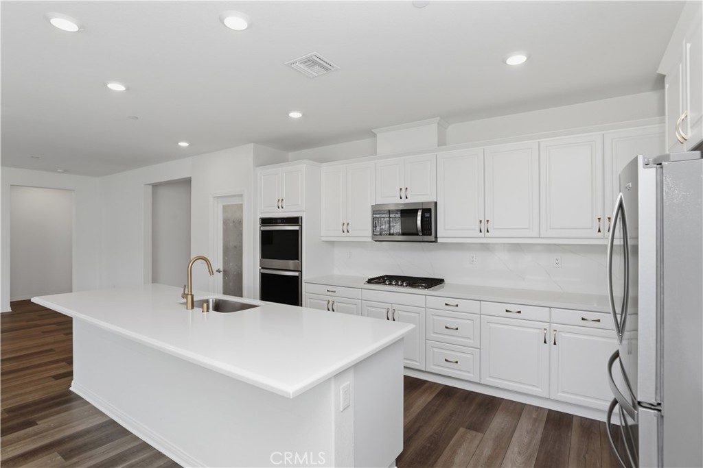 21159 Blue Jeans Court Riverside, CA 92507 - Photo 25 of 63 a kitchen with stainless steel appliances a refrigerator sink and white cabinets