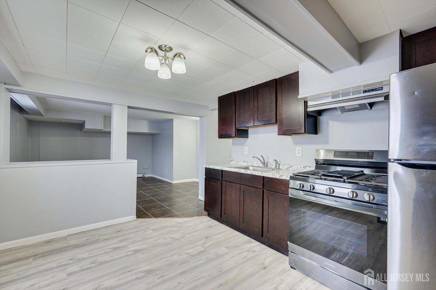 2 Garfield Park Edison, NJ 08837 - Photo 8 of 21 a kitchen with kitchen island granite countertop a stove top oven a sink and dishwasher