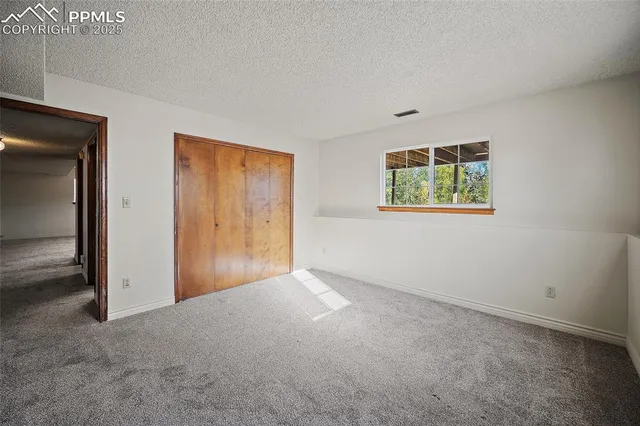 an empty room with windows and closet