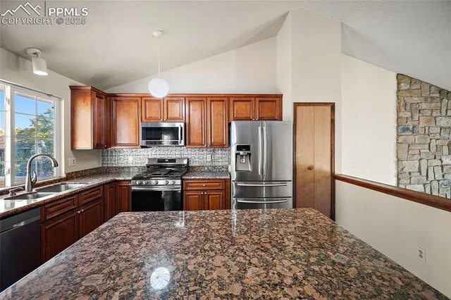 a kitchen with stainless steel appliances granite countertop a refrigerator stove and sink