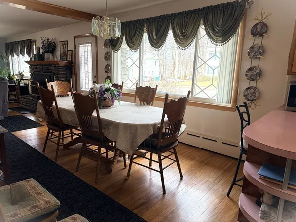 a view of a dining room with furniture a chandelier and wooden floor