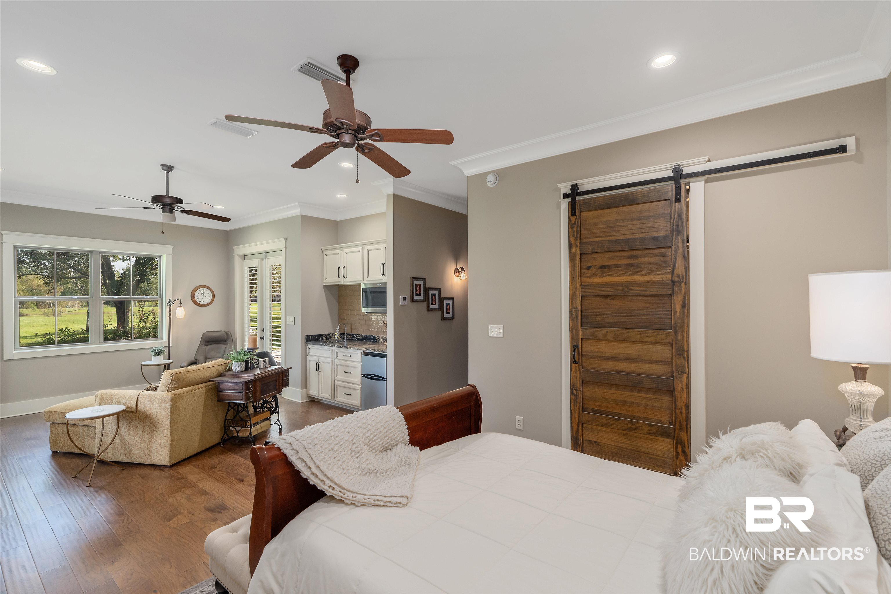 8753 Bishop Road Fairhope, AL 36532 - Photo 40 of 59 Open-concept living area featuring wood-finish flooring, two ceiling fans, and crown molding