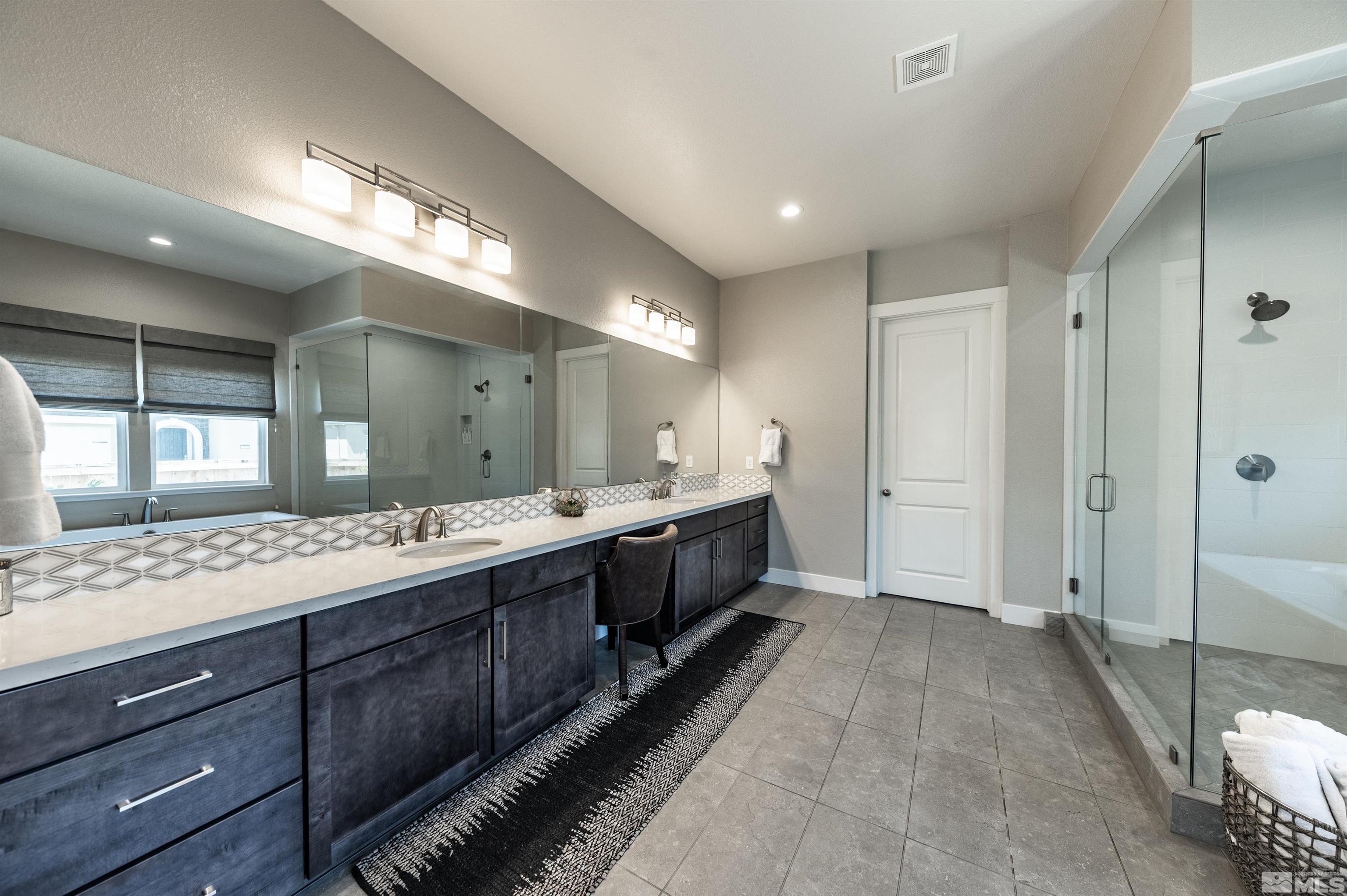 9604 Copperhorn Way Reno, NV 89521 - Photo 19 of 39 a large bathroom with a large mirror vanity and shower