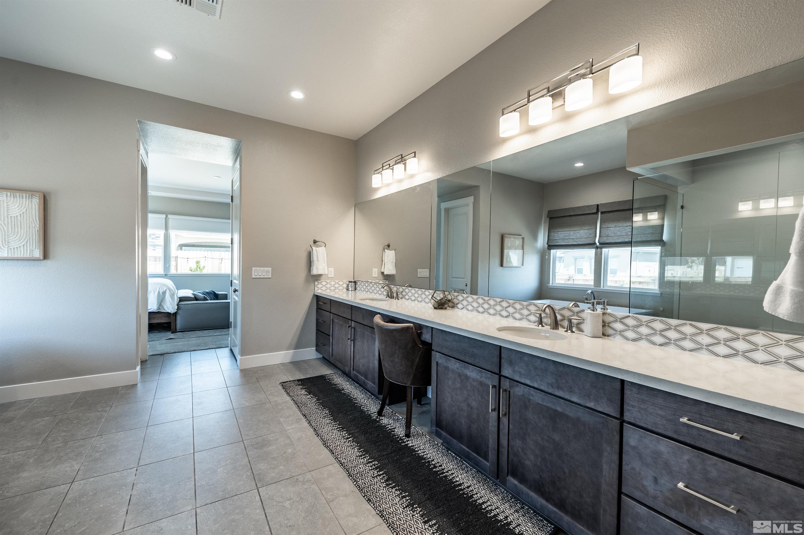 9604 Copperhorn Way Reno, NV 89521 - Photo 22 of 39 a large bathroom with a large mirror vanity and a sink