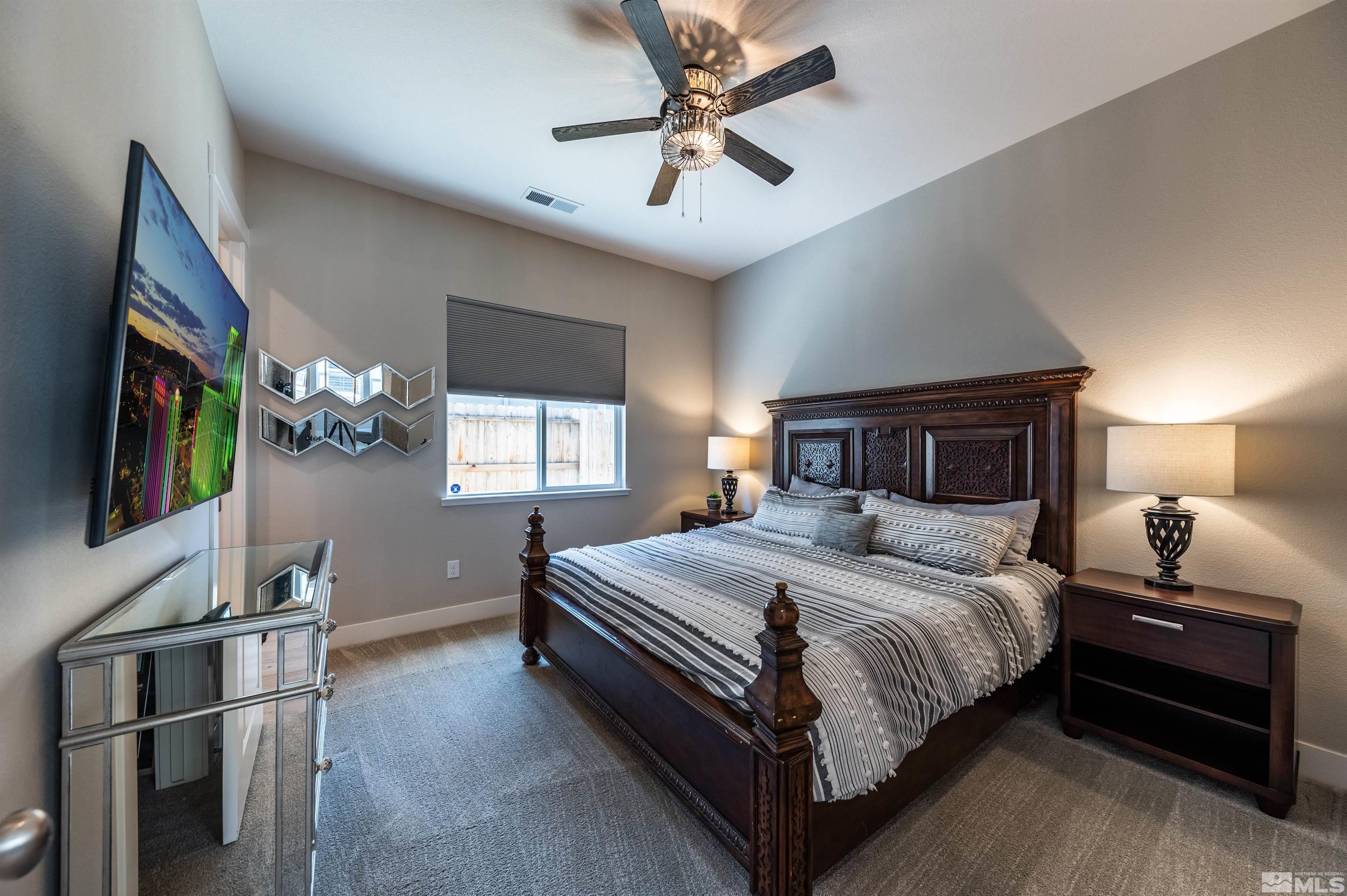 9604 Copperhorn Way Reno, NV 89521 - Photo 27 of 39 a bedroom with a bed and a flat screen tv