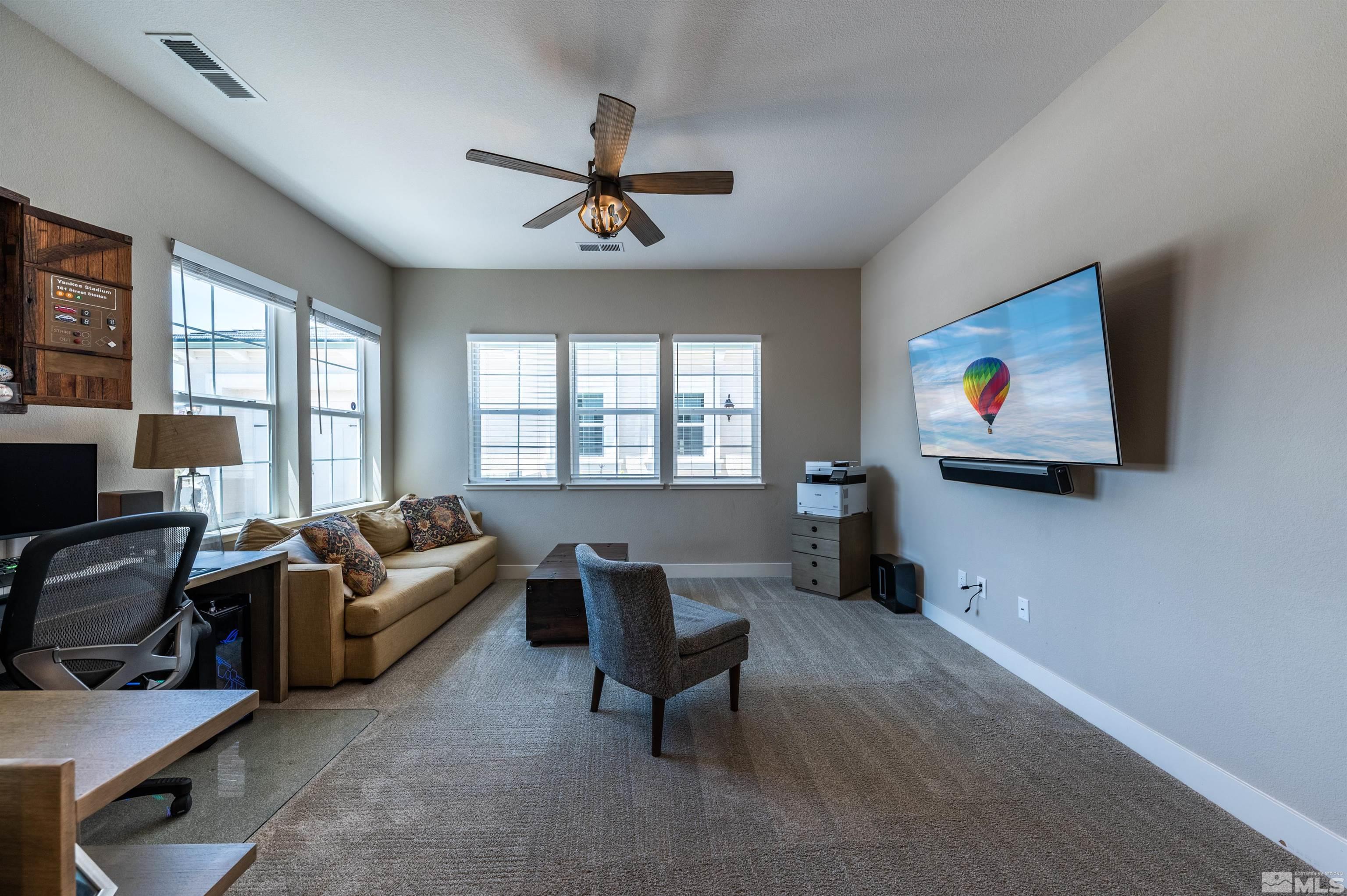 9604 Copperhorn Way Reno, NV 89521 - Photo 29 of 39 a living room with furniture a window and a flat screen tv