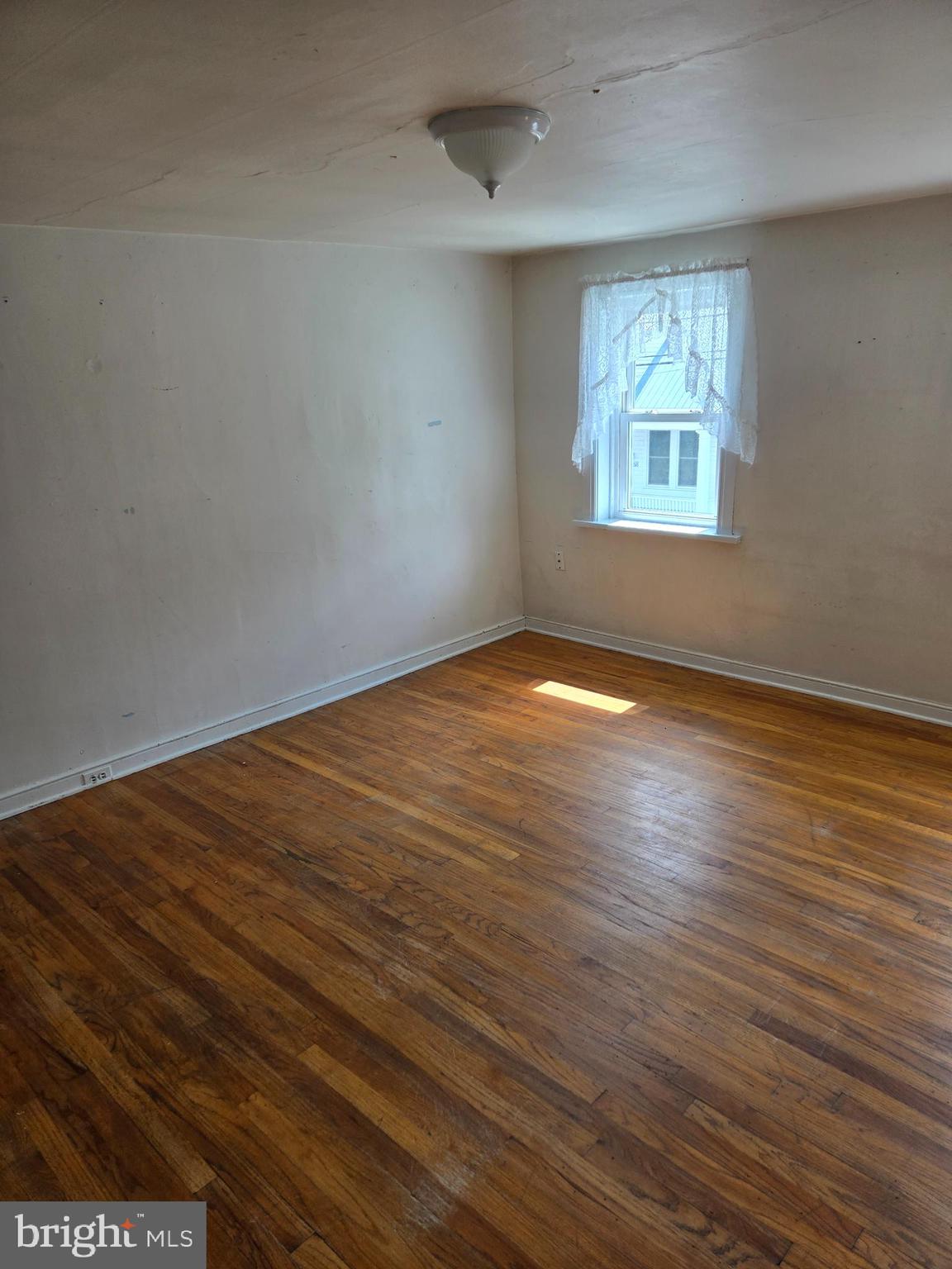 13177 Main Street Fort Loudon, PA 17224 - Photo 21 of 24 an empty room with wooden floor and windows