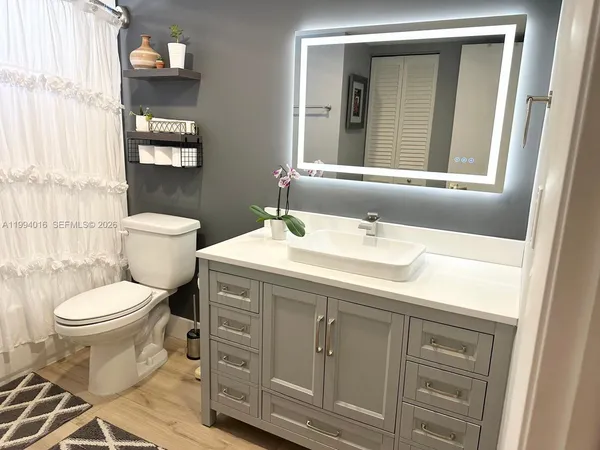 a bathroom with a toilet sink and mirror