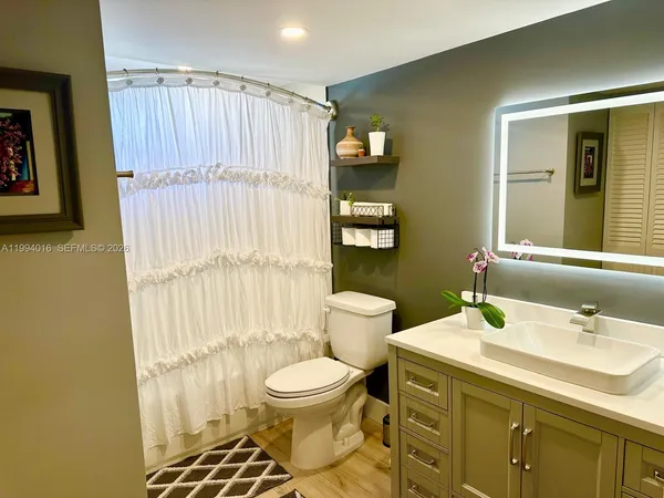 a bathroom with a sink toilet and shower