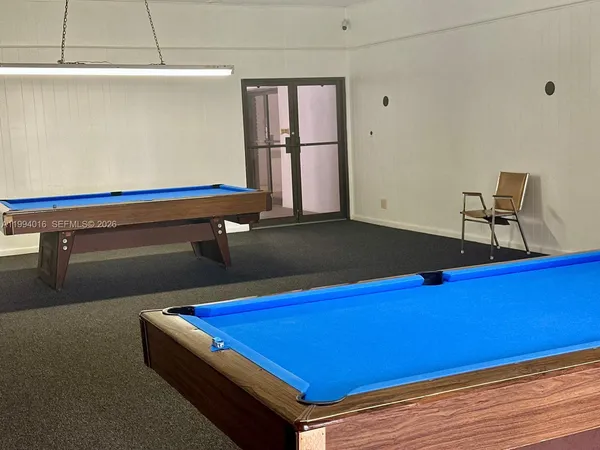 a room with pool table and windows