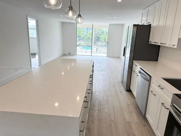 a kitchen with stainless steel appliances a refrigerator sink and wooden floor